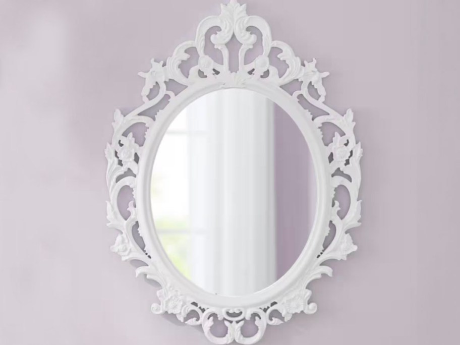 white vintage mirror hanging on purple wall 
