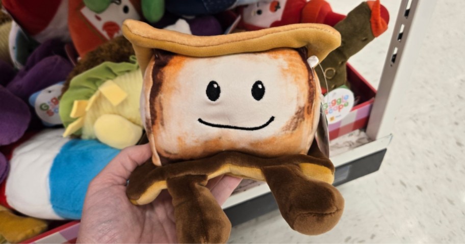 hand holding a plush toy that looks like a S'mores