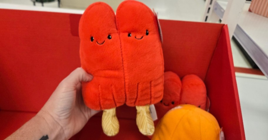 hand holding a red popsicle plush