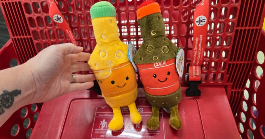 an orange soda and a regular soda plush toys in a Target cart
