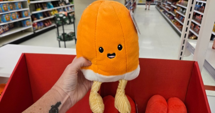 hand holding an orange sherbet ice cream plush toy