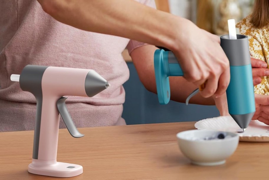 person using a glue gun to make a craft on a table