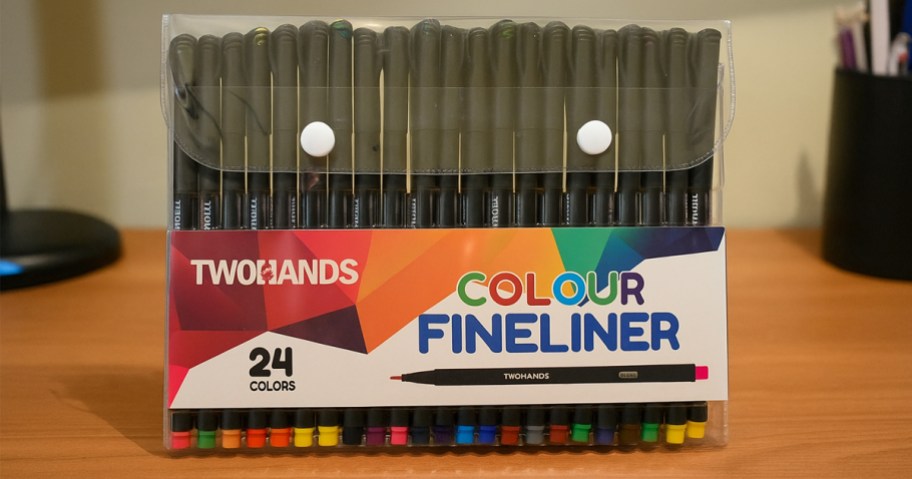 set of colored pens sitting on a desk