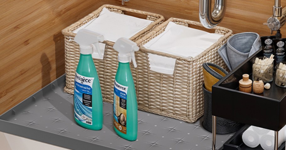 grey mat under sink with cleaning supplies on top