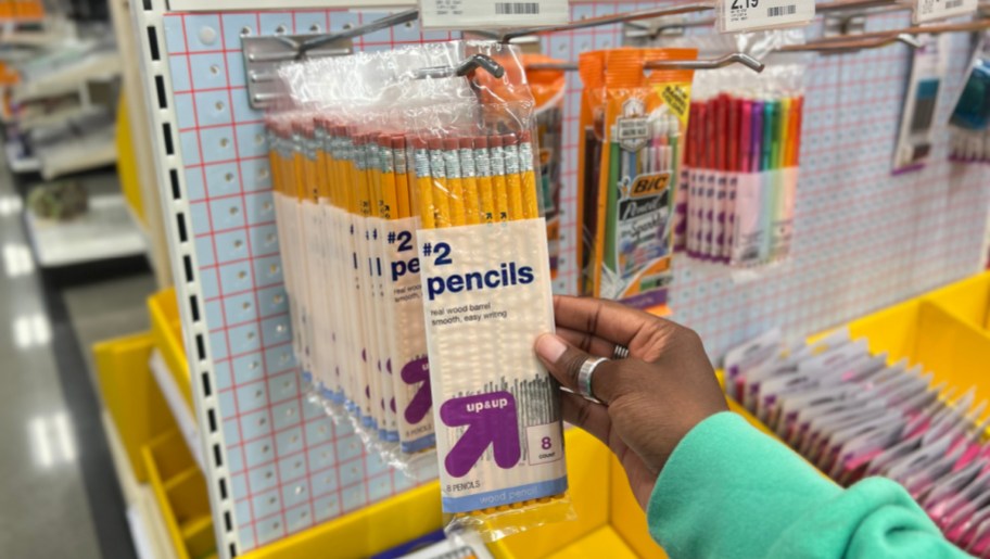 hand pulling a pack of up and up brand pencils off a target store display