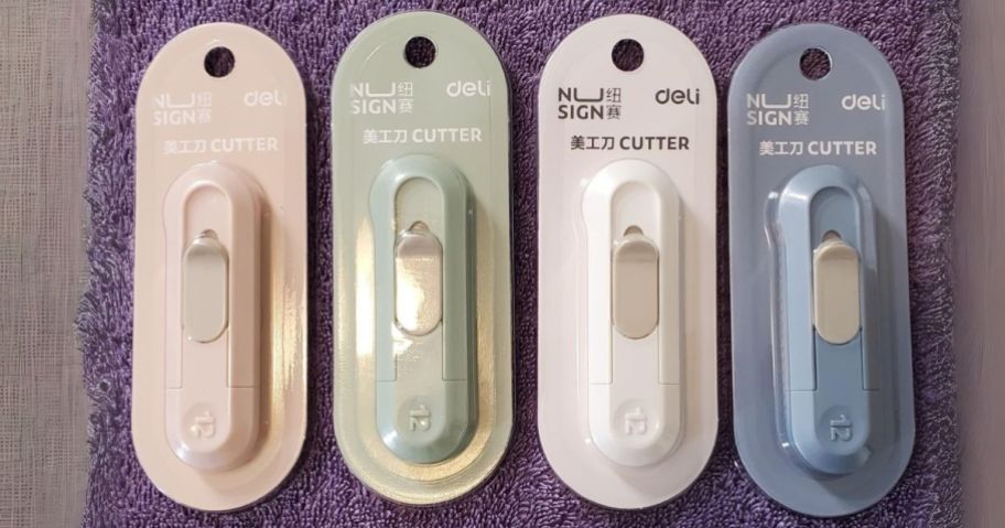 a pink, green, white, and blue utility knife on purple towel