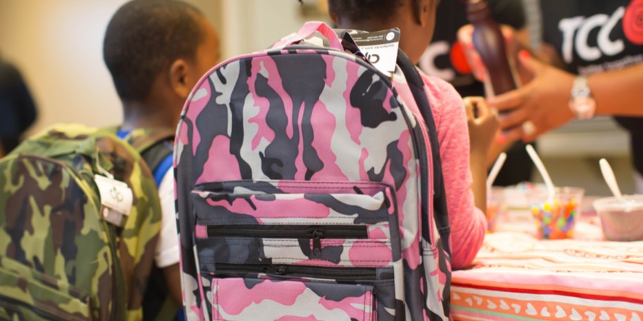 girl wearing pink and black camo backpack