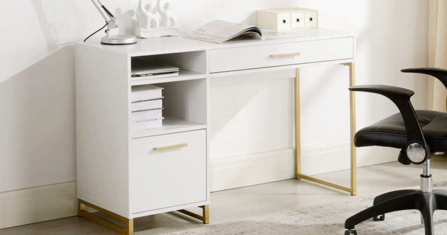 white and gold writing desk with office supplies on top 