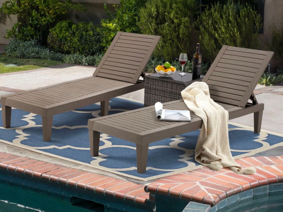 brown lounge chair with magazine and towel laying on top on patio 